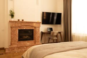 a bedroom with a fireplace with a television above it at Central Apartment Chortkiv in Chortkiv +17 photos
