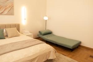 a bedroom with a bed and a green bench at Central Apartment Chortkiv in Chortkiv