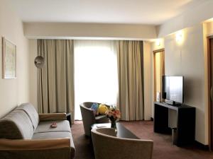 a living room with a couch and a television at Novotel Constantine in Constantine
