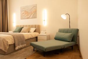 a bedroom with two beds and a chair and a painting at Central Apartment Chortkiv in Chortkiv