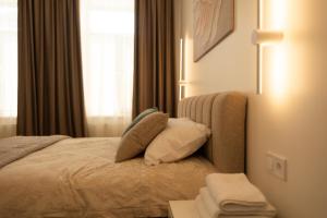 a bedroom with a bed with pillows and a window at Central Apartment Chortkiv in Chortkiv