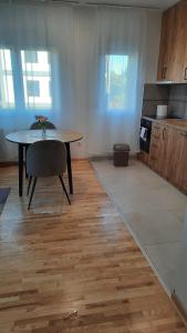 a living room with a table and a kitchen at Apartman Sanja Ledine in Ledine