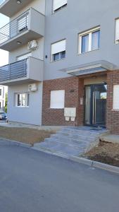 a white building with stairs and a glass door at Apartman Sanja Ledine in Ledine