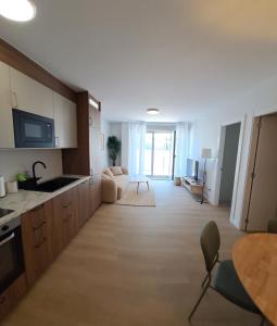 a large kitchen with a table and a living room at Costa Canido II in Malpica +15 photos