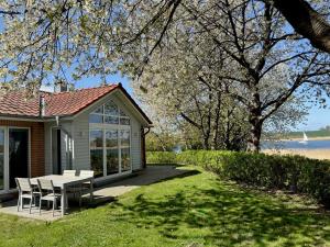 a small house with a table and chairs in the grass at Schlei Resort Marina Hülsen in Kosel