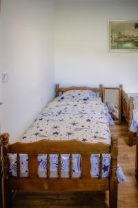 a bedroom with a wooden bed with blue and white sheets at Mountain Home Zaborje in Plužine