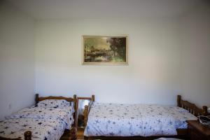 two beds in a room with a picture on the wall at Mountain Home Zaborje in Plužine