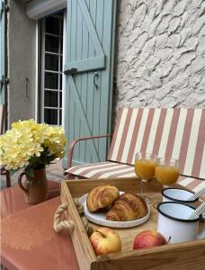 a table with a tray of bread and orange juice at Maison Joviale in La Ferté-Saint-Aubin +17 photos
