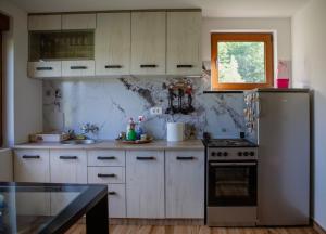 a kitchen with white cabinets and a stove top oven at Mountain Home Zaborje in Plužine