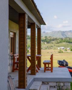 a porch of a house with a table and a bench at Mountain Home Zaborje in Plužine