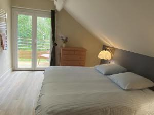 a bedroom with a bed and a sliding glass door at Maison Joviale in La Ferté-Saint-Aubin