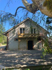 a house with a deck on the side of it at Maison Joviale in La Ferté-Saint-Aubin