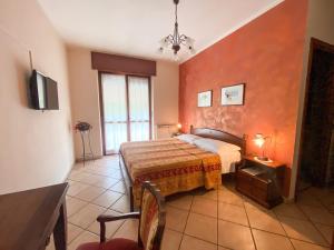 a bedroom with a bed with an orange wall at Cà 'd Gnese in Castagnole Lanze