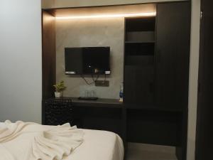 a bedroom with a bed and a tv on a wall at Aleida Residency in Cochin +28 photos