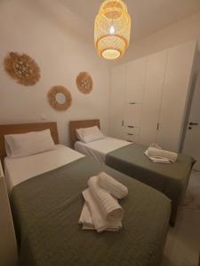 a bedroom with two beds with towels on them at Le Blé Home in Mérikhas