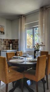 a dining room table with chairs and a window at Apartman Mara in Risan