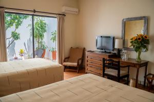 a bedroom with a bed and a desk with a television at Parador del Dominico in Oaxaca City +26 photos