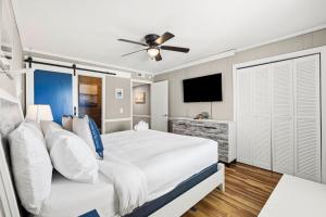 a bedroom with a large bed with a ceiling fan at The Beach Is Back in Myrtle Beach +62 photos