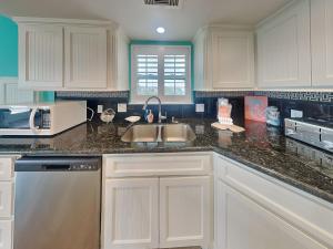 a kitchen with a sink and a microwave at Sundancers in Galveston
