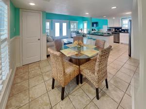 a dining room with a table and chairs in a kitchen at Sundancers in Galveston +9 photos