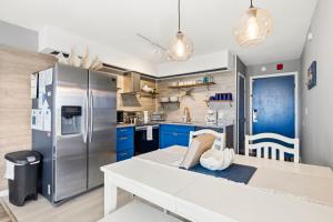 a kitchen with blue cabinets and a stainless steel refrigerator at The Beach Is Back in Myrtle Beach