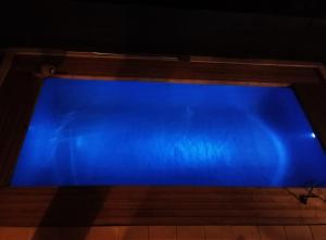 a blue swimming pool with a wooden frame at Ulivo Apartment in Ragusa
