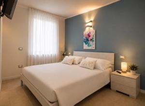 a bedroom with a large white bed with two pillows at ES Apartments in Nago-Torbole