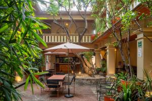 a patio with a table and chairs and an umbrella at Parador del Dominico in Oaxaca City