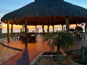a large straw umbrella on the beach with tables and chairs at Beach Studio 7 in San Felipe +13 photos