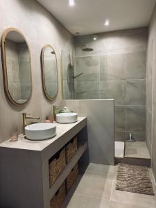 a bathroom with two sinks and a shower at Copacabane in Gujan-Mestras