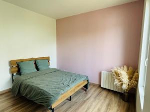 a bedroom with a bed and a wall at Copacabane in Gujan-Mestras
