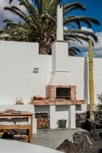 a fireplace in a patio with a palm tree at Villa Lore by Villalize in Teguise