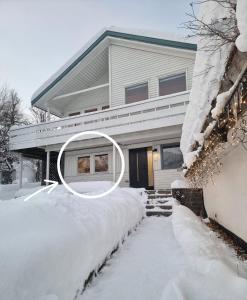 a house with a pile of snow in front of it at Central apartment in Tromsø