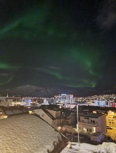 an image of a city with the aurora in the sky at Central apartment in Tromsø