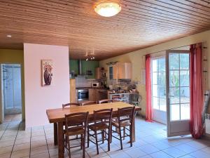 a kitchen with a wooden ceiling and a table and chairs at La Pierre Lotie in Saint-Denis-dʼOléron +11 photos