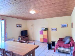 a living room with a table and a bed at La Pierre Lotie in Saint-Denis-dʼOléron