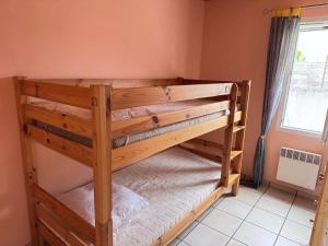 a wooden bunk bed in a room with a window at La Pierre Lotie in Saint-Denis-dʼOléron