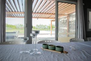 a table with wine glasses and a tray of green dishes at Pepi Sobe in Čepin