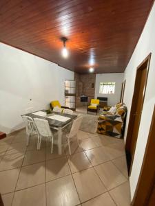 a dining room and living room with a table and chairs at Recanto Vieira in Lages