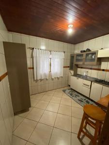 a small kitchen with white tiled walls and ceilings at Recanto Vieira in Lages
