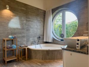a bathroom with a tub and a large window at Schlei Resort Marina Hülsen in Kosel +264 photos