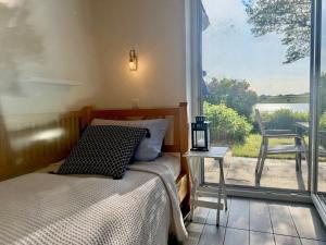 a bedroom with a bed and a window with a view at Schlei Resort Marina Hülsen in Kosel