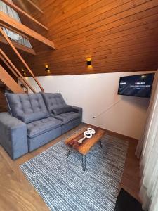 a living room with a couch and a table at Amorência Chalé Luz da lua in Campo Largo