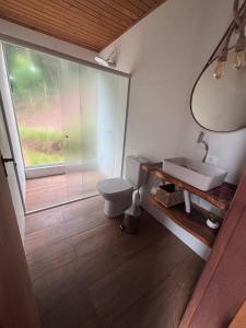 a bathroom with a toilet and a sink and a window at Amorência Chalé Luz da lua in Campo Largo +5 photos