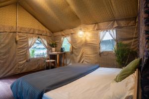a bedroom with a bed in a tent at Aloha Riverside in Kasol