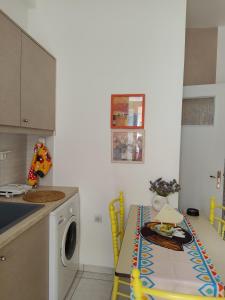 a kitchen with a table and a washing machine at Manolia !!! in Kranidi +8 photos