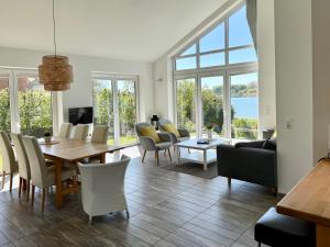 a living room with a table and chairs and a large window at Schlei Resort Marina Hülsen in Kosel