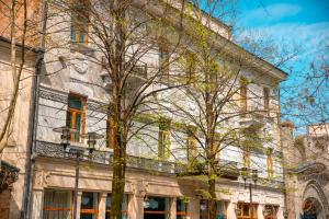 a building with a tree in front of it at Belona Hotel in Kutaisi