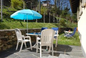 a table and chairs and an umbrella on a patio at Serenita in Gambarogno