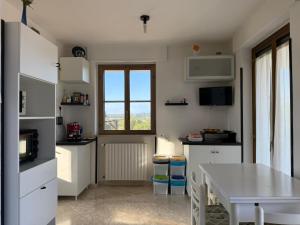 a kitchen with white cabinets and a table and a window at Happy's Casa in Putignano